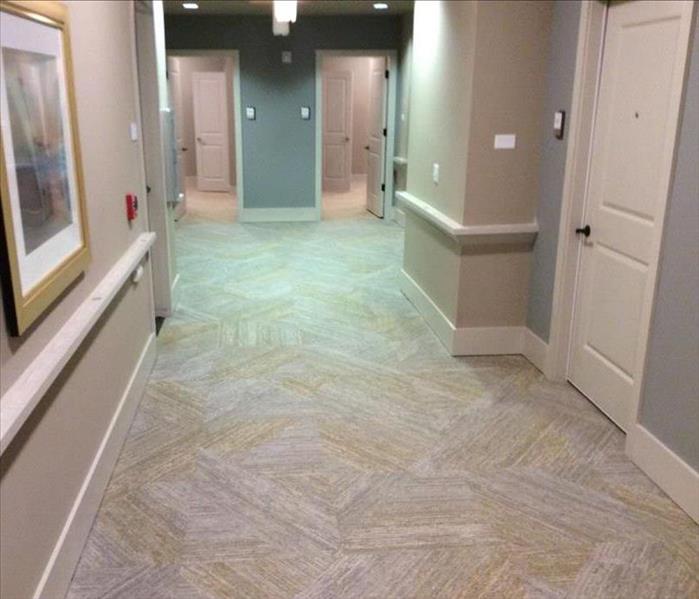 empty hallway with gray and yellow carpet and gray and cream walls 