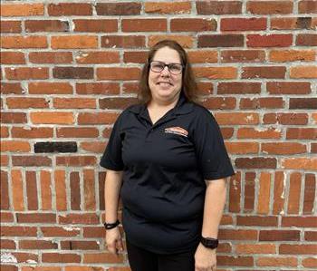 man in servpro shirt standing in front of brick wall