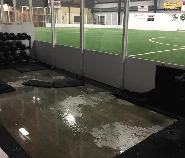 water on ground of indoor soccer field and workout area