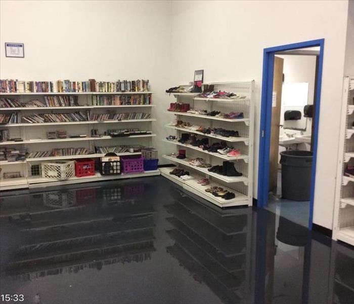 corner of store with book shelves filled with books with water on ground
