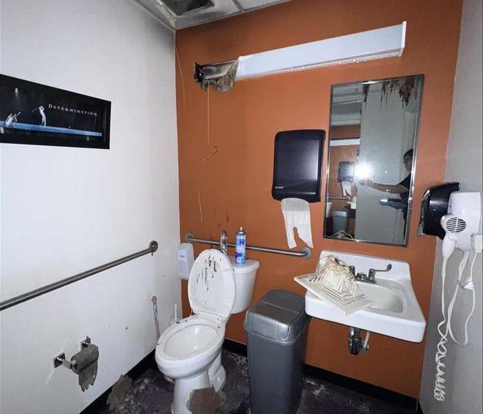 bathroom with orange walls with fire damage on lighting equipment 